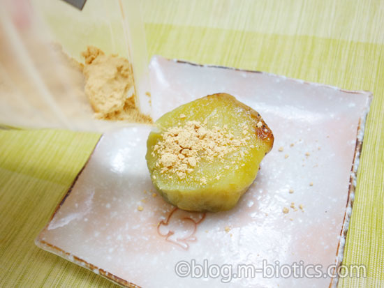 きな粉芋（さつまいものきな粉まぶし）作り工程　皿にのせた焼き芋にきな粉をかけているところ