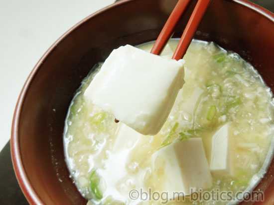 さとの雪食品　ずっとおいしい豆腐　味噌汁　豆腐を箸で持ったところ