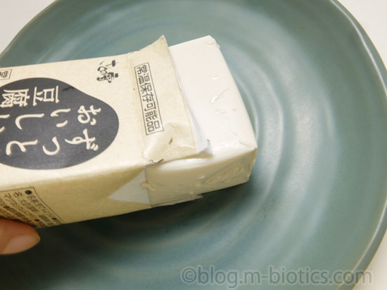 さとの雪食品　ずっとおいしい豆腐　パッケージから滑り出させているところ