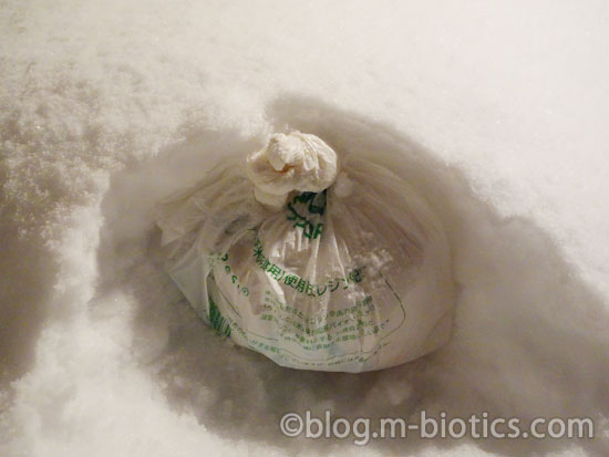 北海道 冬 外の雪に食べ物を埋める うどん 袋を置いているところ